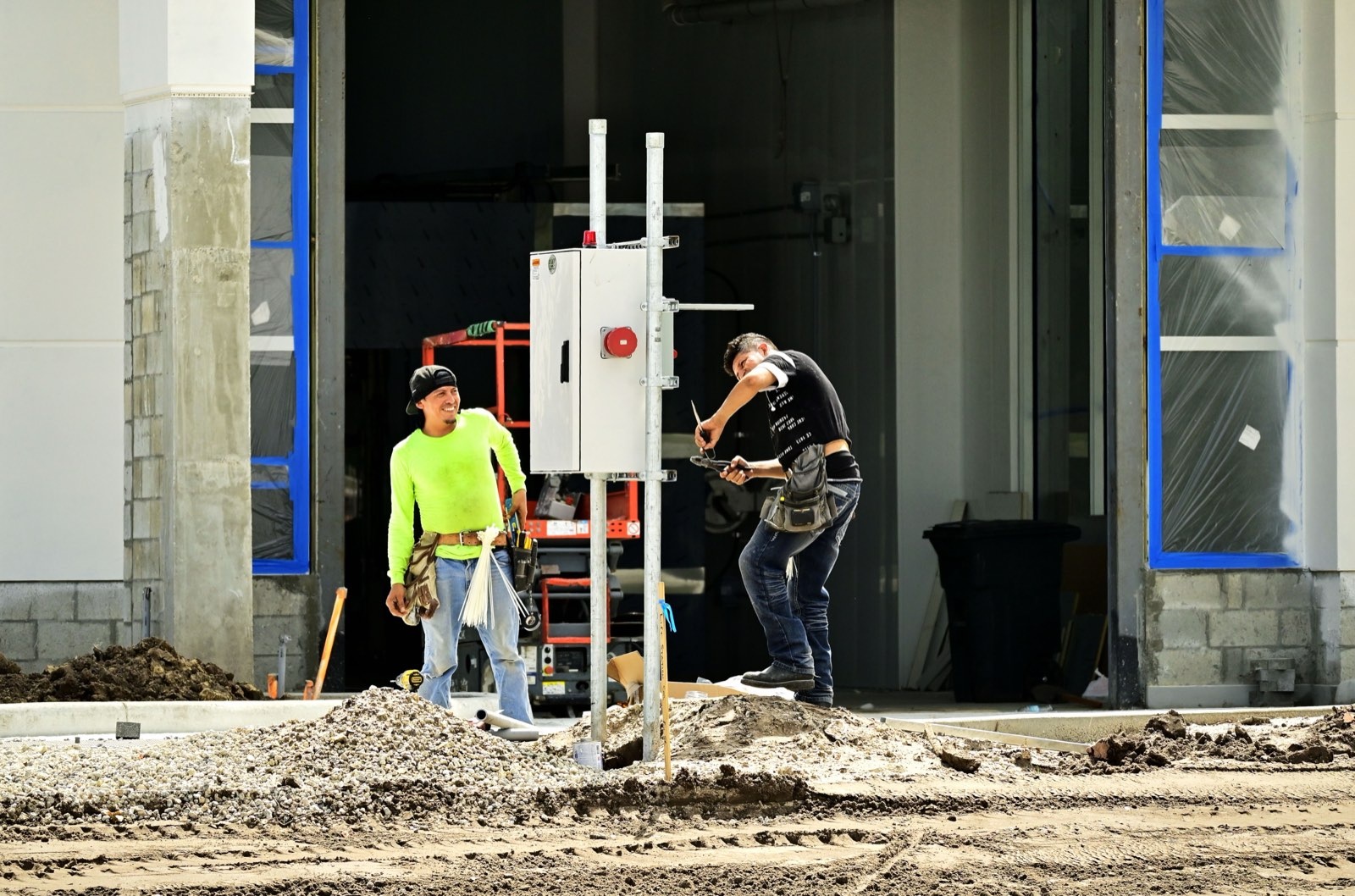 Electricians wiring a temporary power panel on an Inland Empire job site